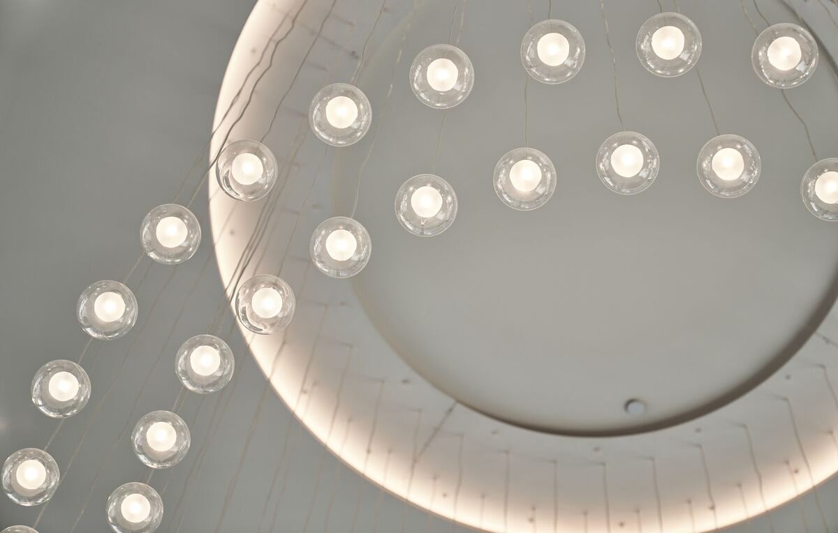 A view of the ceiling that is white with 2 strings of light in an arch