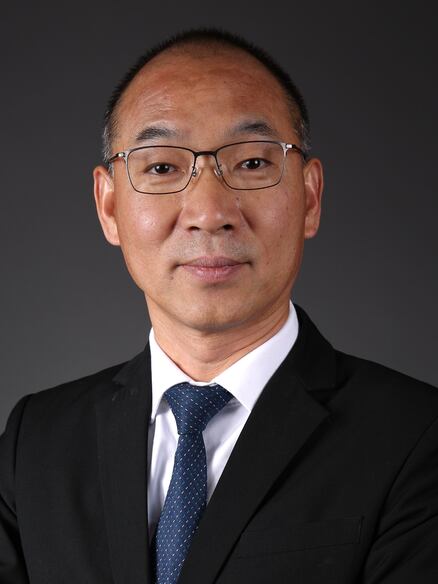 Male in dark suit, white shirt and blue tie