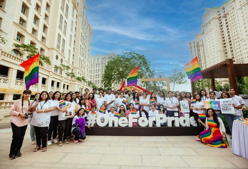 Individuals holding pride flags with at sign that says #oneforpride