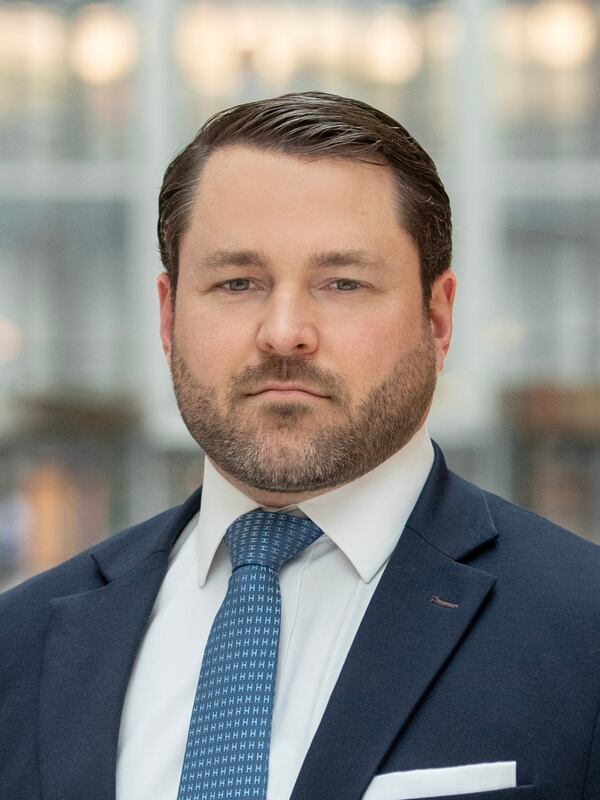 Business man wearing blue blazer, white shirt and blue tie. Short cut beard Caucasian looking man.