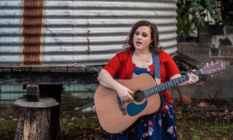 female performing with a guitar