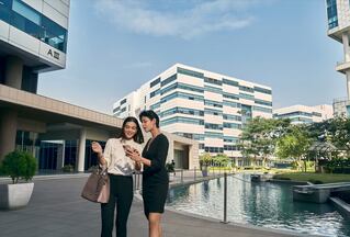 two women talking in front of a building