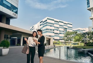 two women talking in front of a building