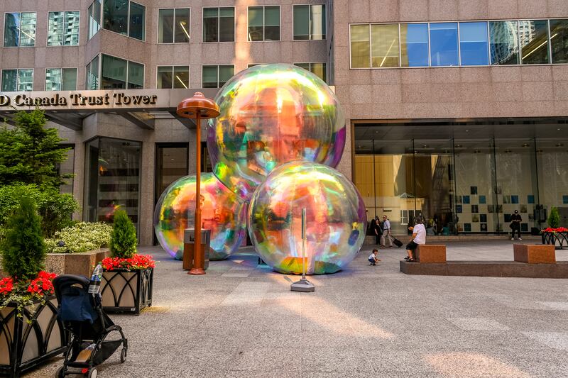 larger-than-life bubble artwork surrounded by office buildings at day time
