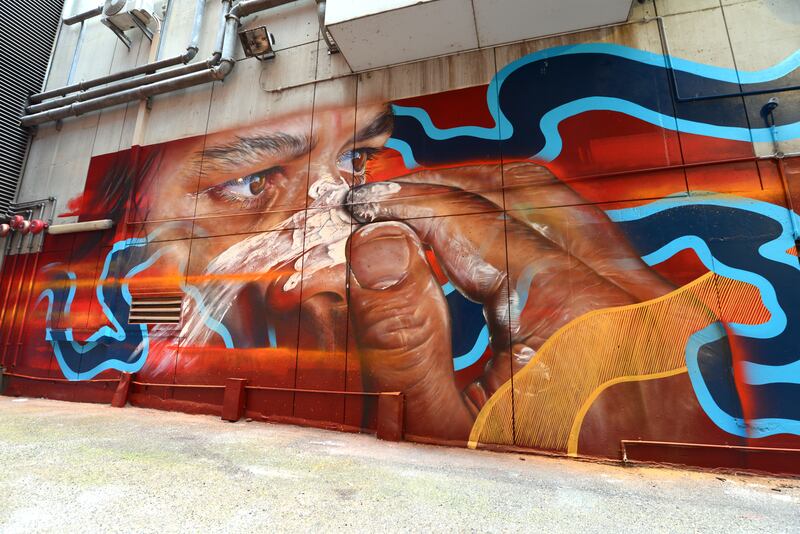 mural of an aboriginal male putting ceremonial face paint on