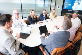 Eight individuals from the United Kingdom leadership team at a conference table