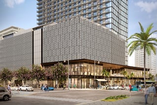 external view of building on street corner with cars and people walking