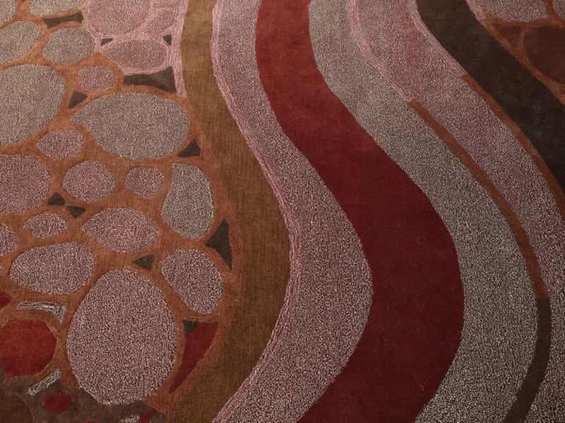 orange, red and brown curvy lines rug up close