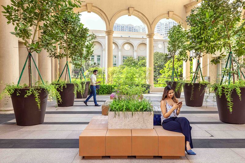 woman on cell phone in outside garden plaza