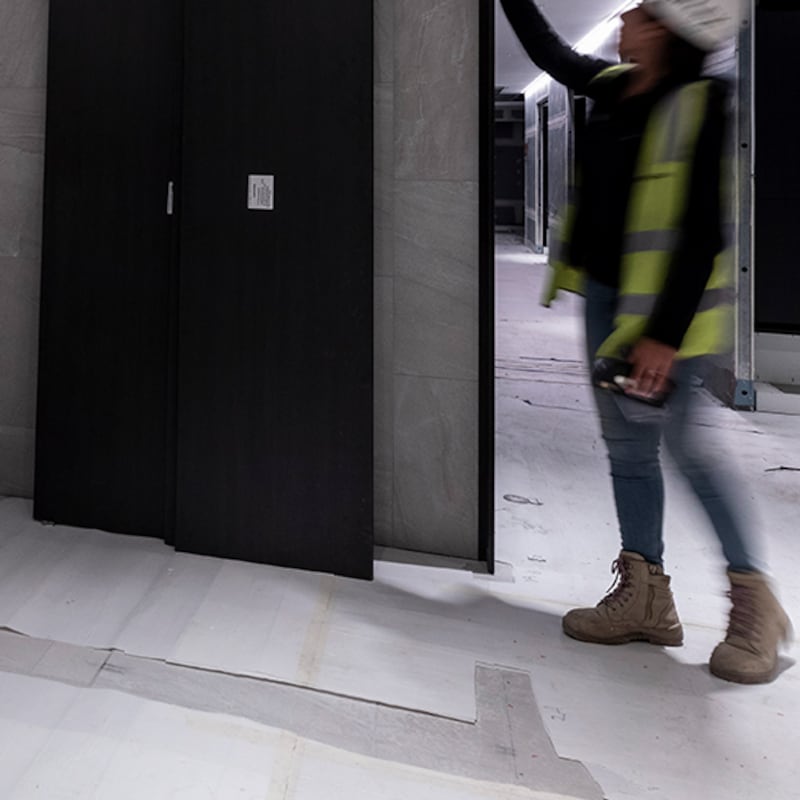 man on construction site checking wall