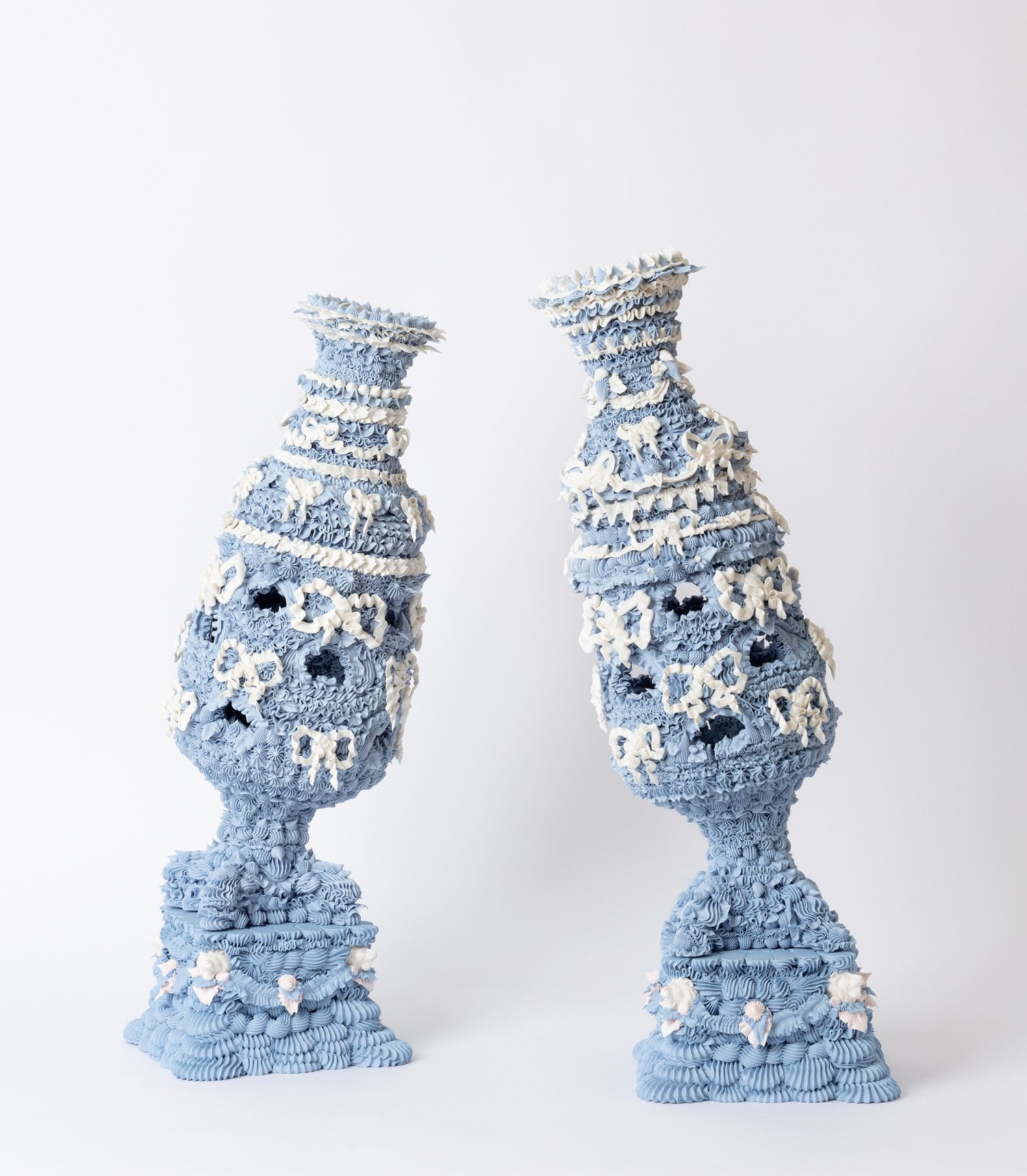 Two blue sculptures that are blue with white bow decorations