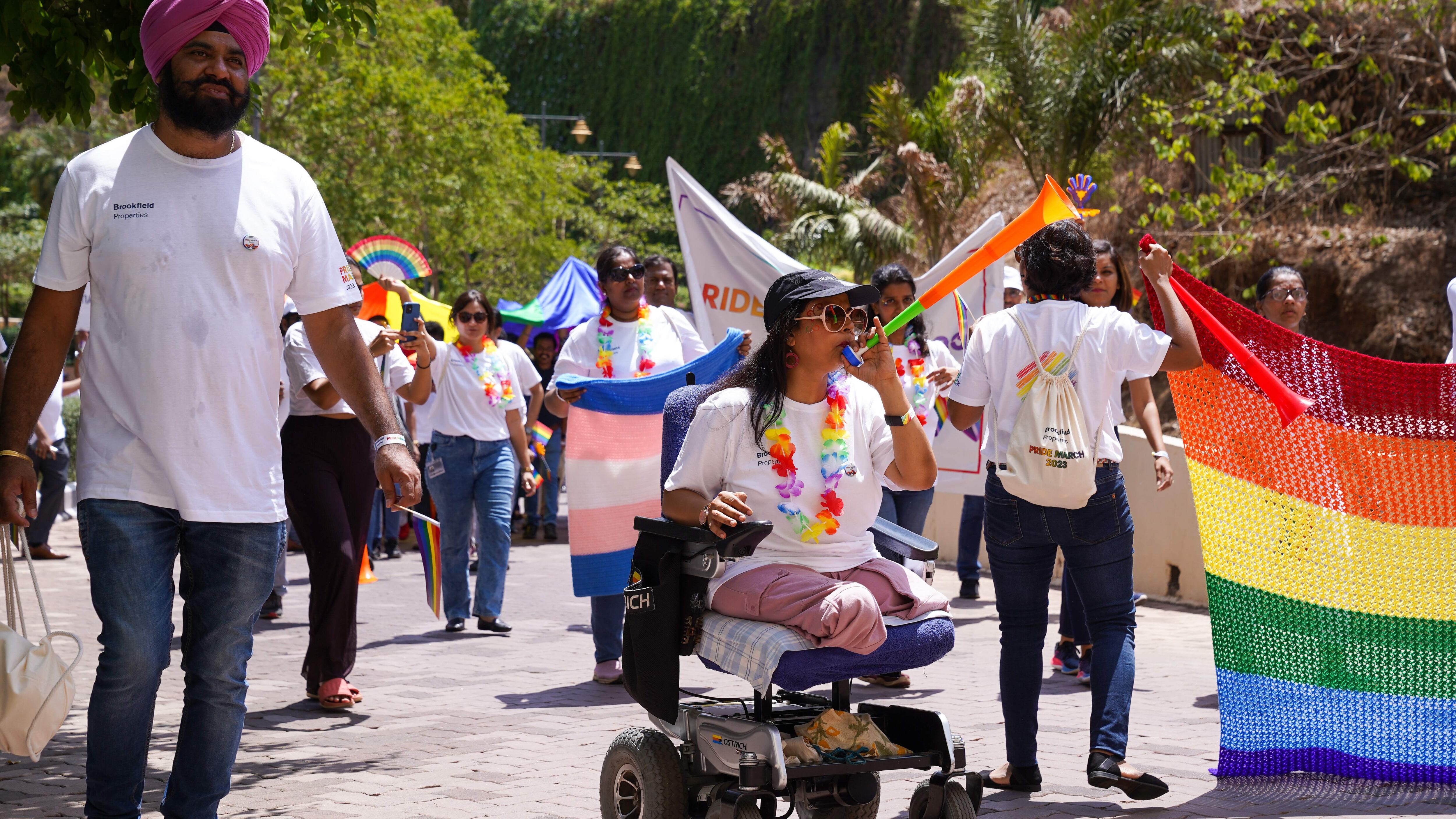 woman in wheelchair, others in pride parade
