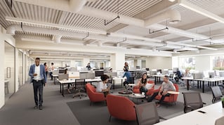 modern office space with desks, soft seating orange chairs around low small table