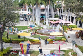 outdoor event in green space with colorful spinning rides