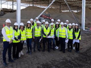 A group of business people touring a construction site wearing bright yellow vests