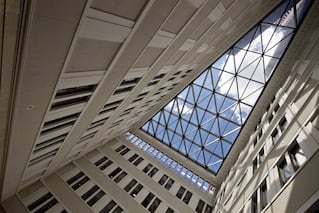 Looking up at the sky through a building's skylight.