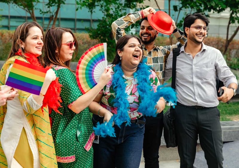 Five Individuals that are smiling and dressed in colorful apparel and accessories