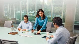 three people in office conference room