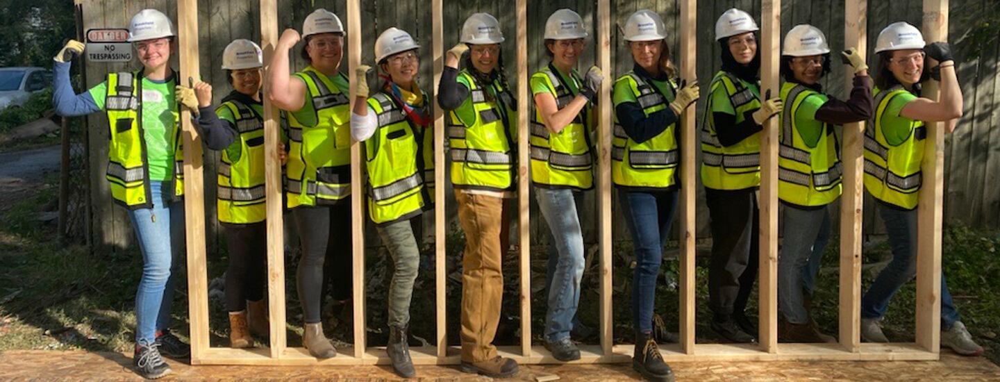 construction workers and volunteers standing in building infrastructure