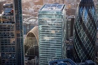 A very tall square glass building in the city's downtown