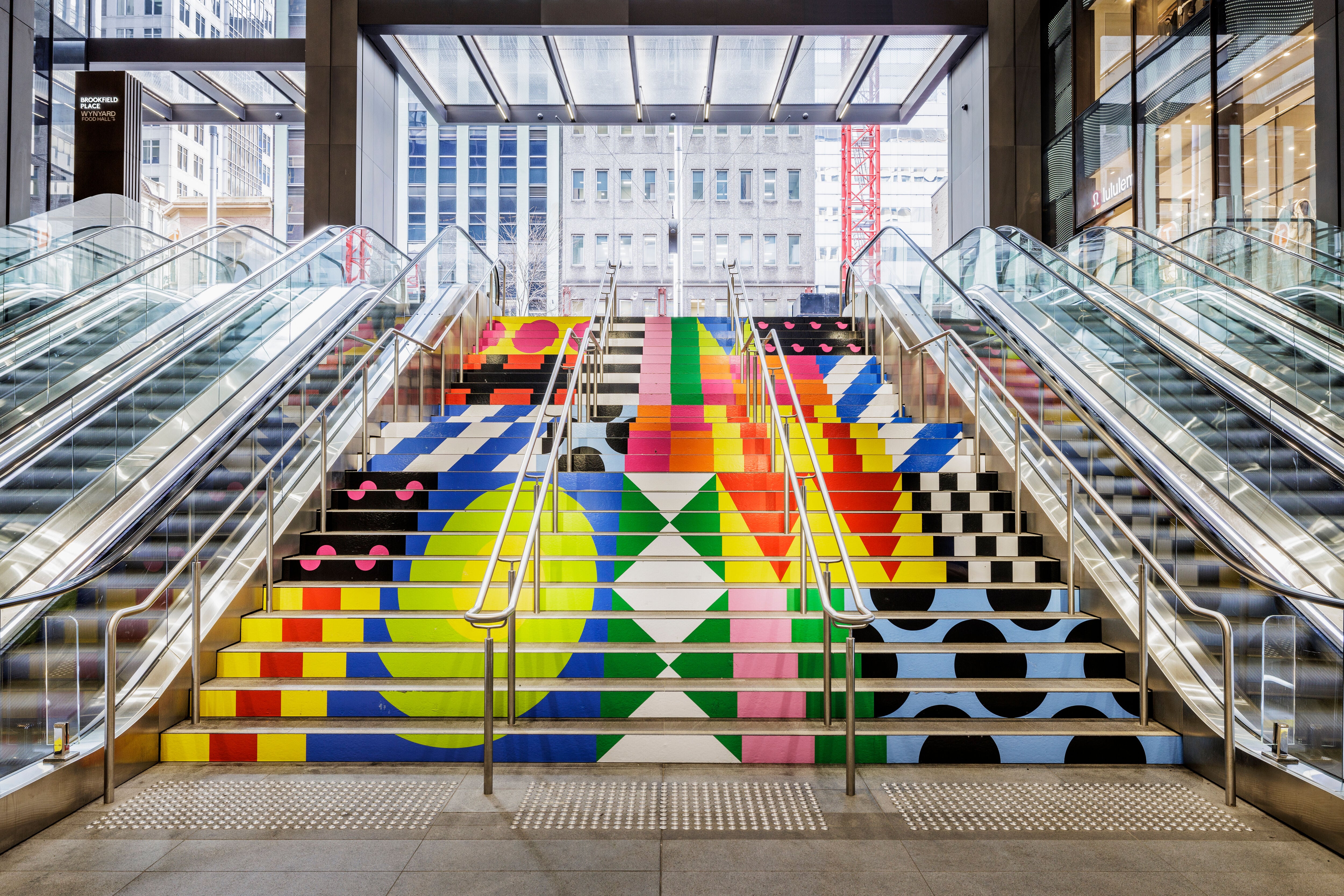 artwork on a staircase between two escalators
