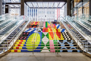 artwork on a staircase between two escalators