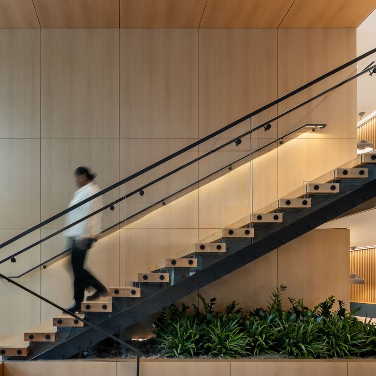 woman in white shirt walking downstairs in office