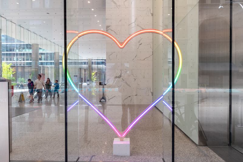 colorful, heart-shaped neon light in office building window