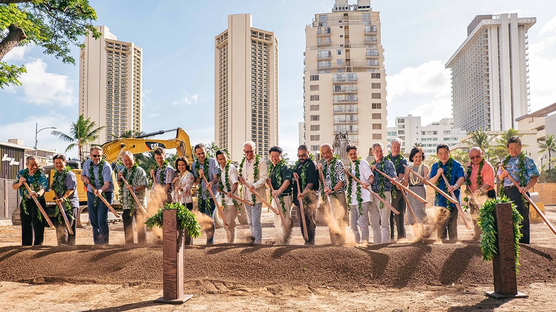 People with shovels breaking ground