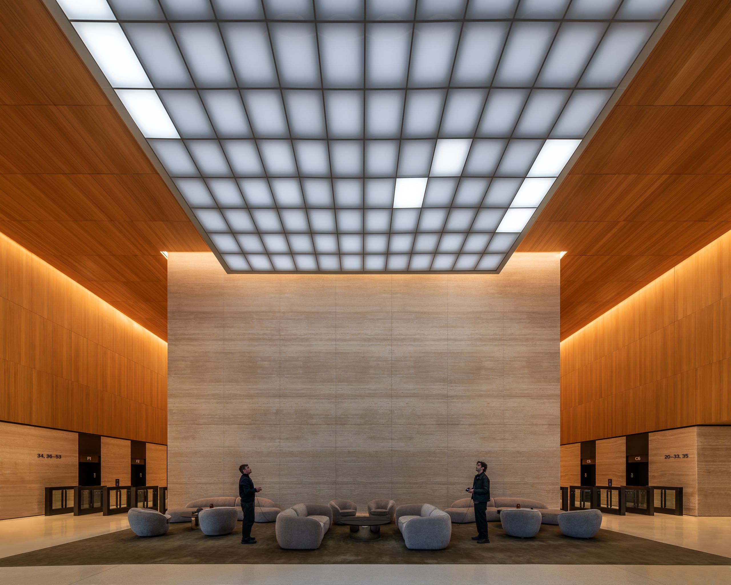 An image of the artwork "A:: Light" by Pierre Huyghe in the lobby of One Liberty Plaza, NYC. Two people are pictured interacting with the installation.