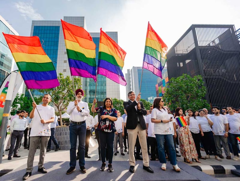 Four individuals, each holding pride flags at the beginning of the pride march