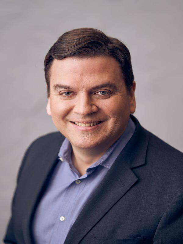 Photo of a man in a blue blazer and light blue shirt