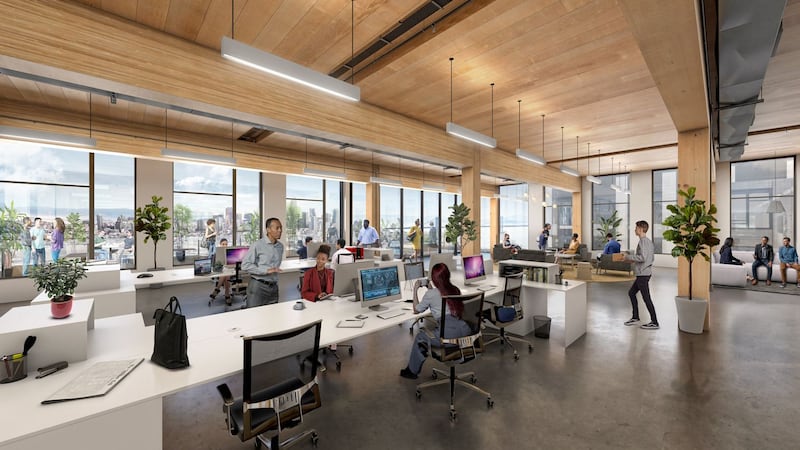 An open-concept office space with people working at shared desks.