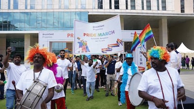 people with rainbow wigs playing drums and marching with signs