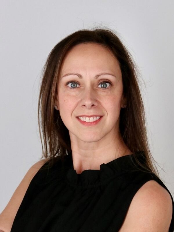 White woman wearing a black sleeveless top with her arms folded