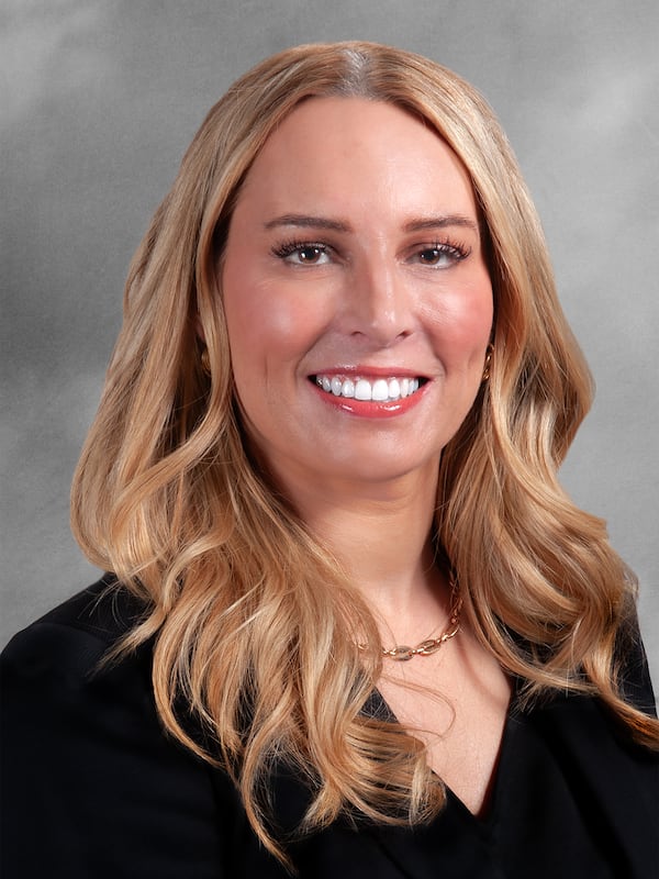 A woman with blonde hair wearing a dark shirt