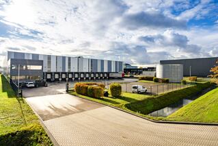 Amsterdam - exterior view of blue and white logistics building with 14 docks and parking area.