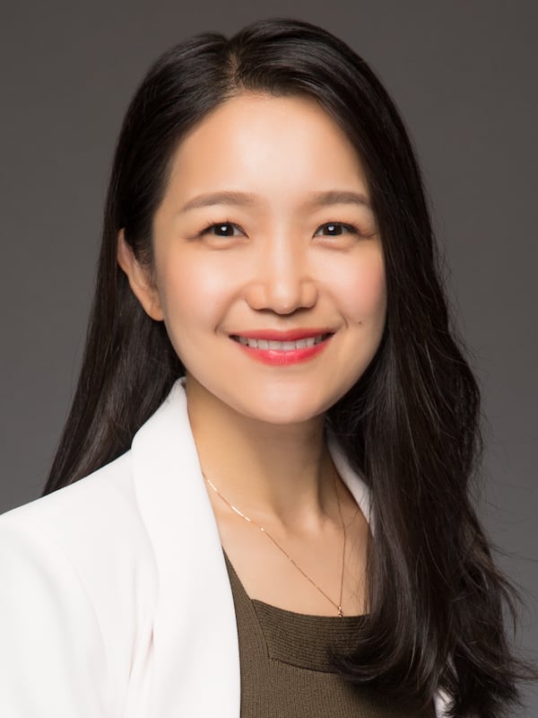 female with white blazer and olive green top