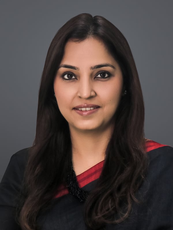 Woman headshot wearing black and red top with long dark hair