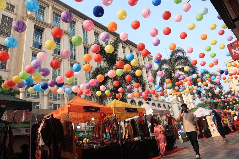 Outdoor walkway with storefronts and balloons hanging overhead