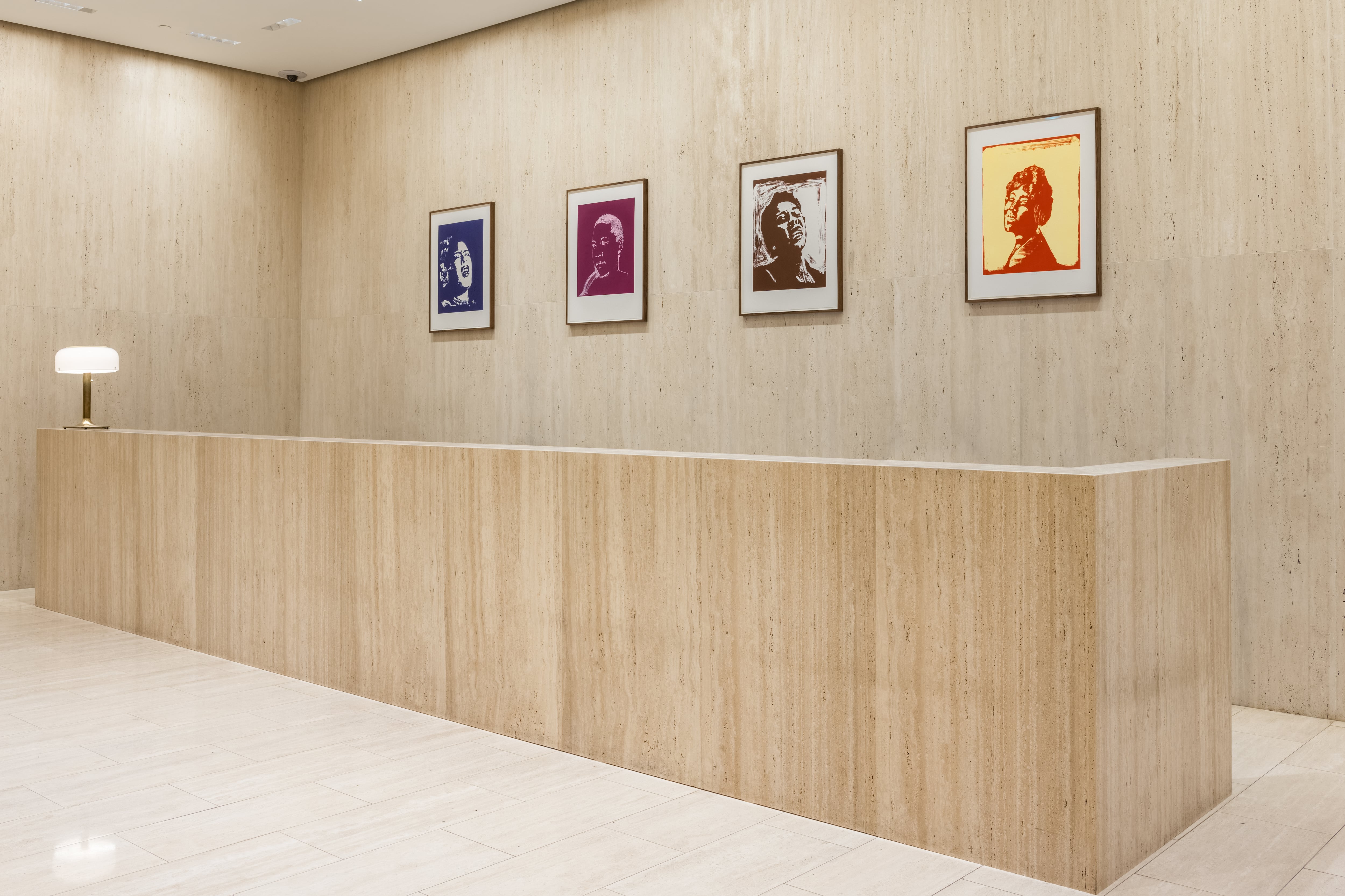 four pieces of art by Thomas Schütte hung along the wall behind the reception desk