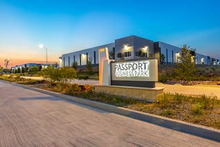 picture of the outside of a warehouse with a sign that says "Passport Business Park" in capital letters in the foreground