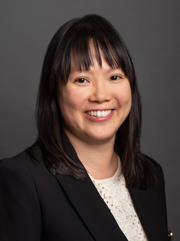 Women in black suit and white shirt smiling at camera