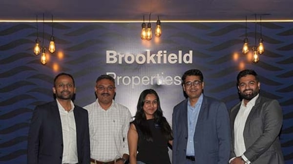 Group photo at Brookfield Properties' 'The Social Hours' networking event, featuring five professionally dressed attendees standing in front of a branded backdrop with modern lighting.