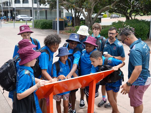 A group of boys reading a display together