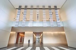 large entry way with person standing near hallway with elevators