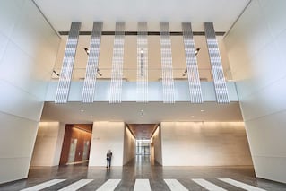 large entry way with person standing near hallway with elevators