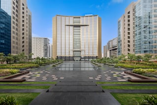 A large building with a big area in front with some water
