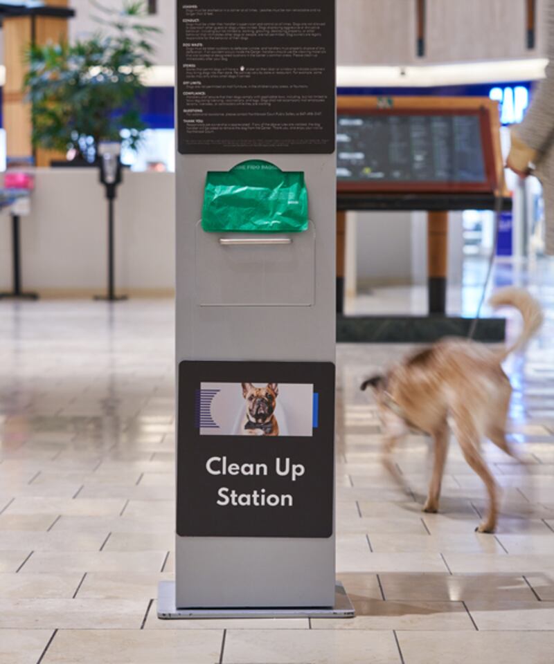 blurred dog behind clean-up station at mall