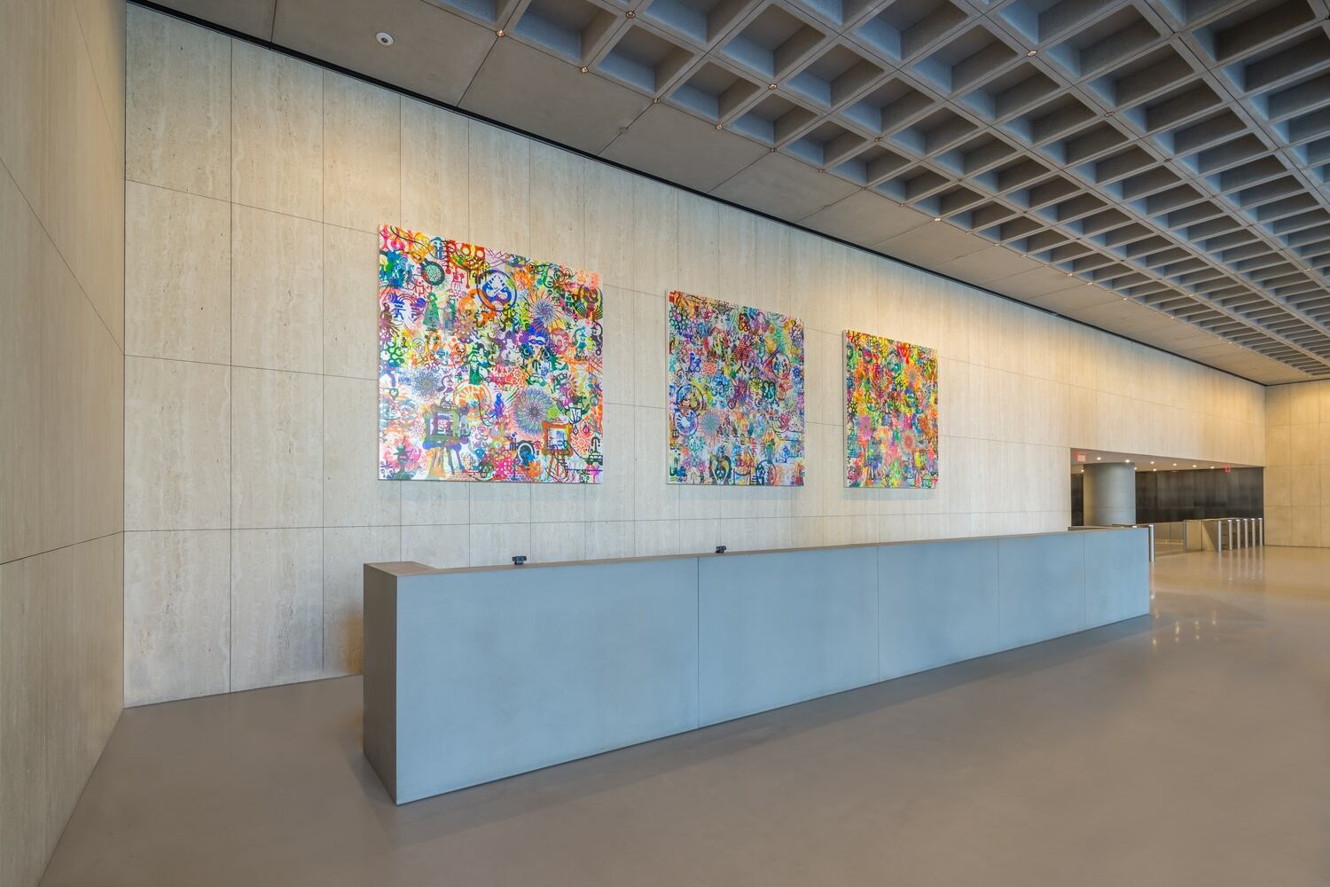 Three pieces of artwork displayed behind a reception desk.